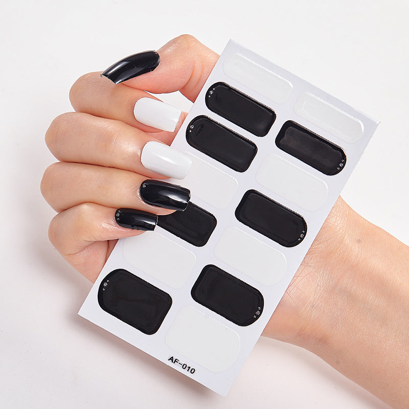 Every Shade of You nail wraps featuring black and white designs held in a hand with manicured nails.