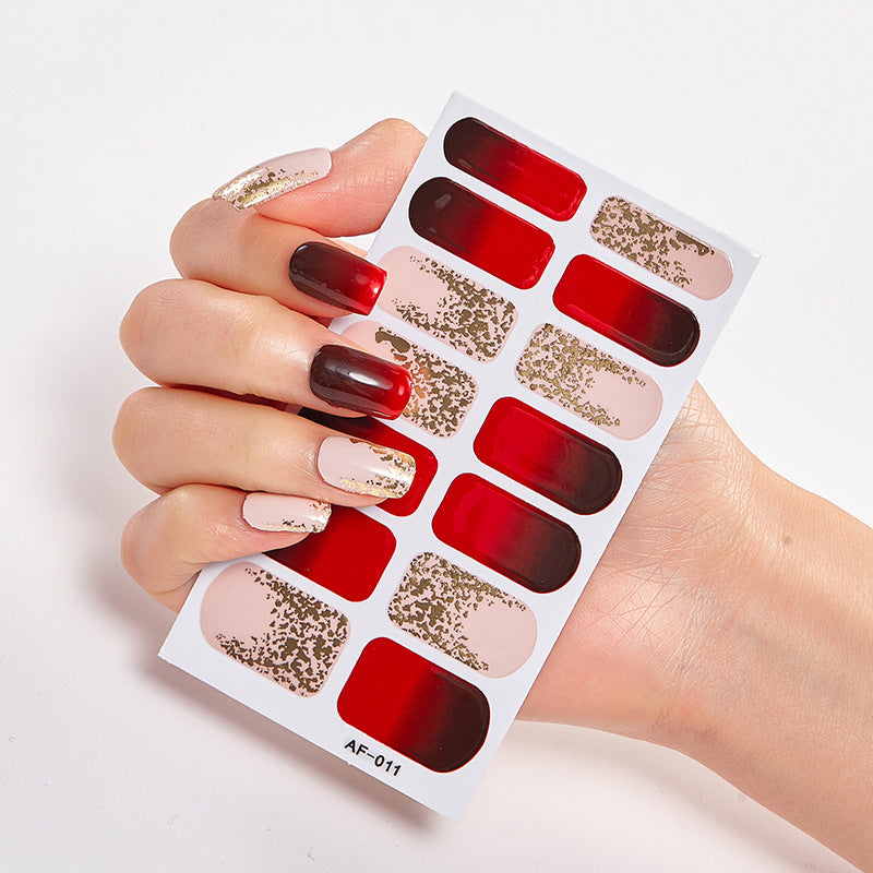 Every Shade of You nail set featuring red, nude, and gold designs on a hand holding a display sheet.