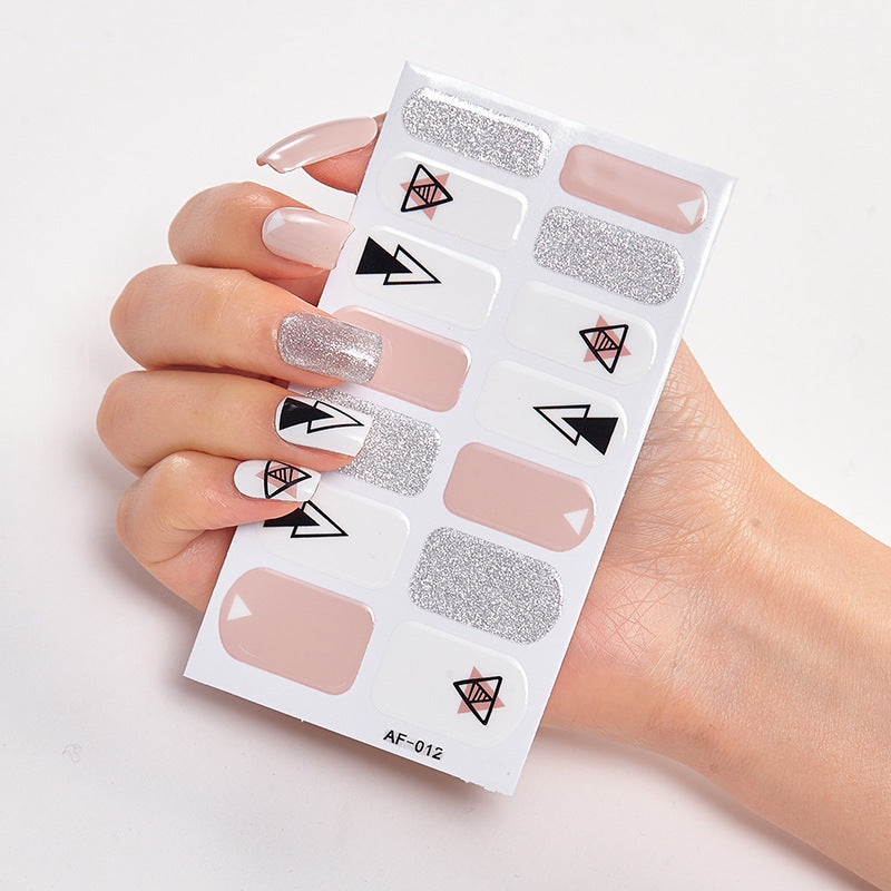 Nail art set featuring various designs, including nude, silver, and geometric patterns on a white display sheet.