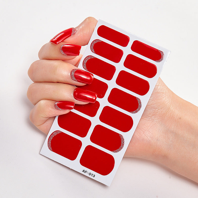 Red nail wraps displayed on a hand with long, glossy red nails and silver glitter accents.