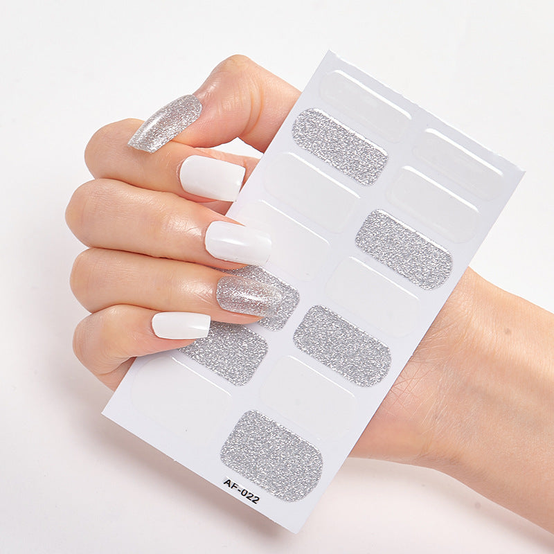 Every Shade of You nail art set with white and silver glitter designs on a hand holding a nail sticker sheet.
