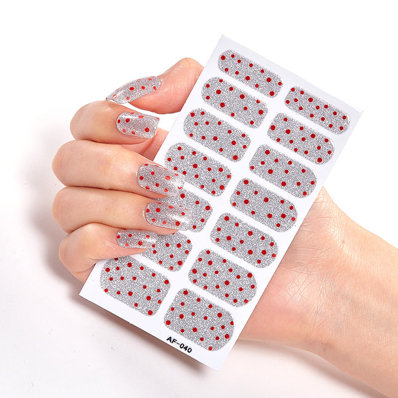 Every Shade of You nail stickers with clear base and red polka dots, held in a hand.