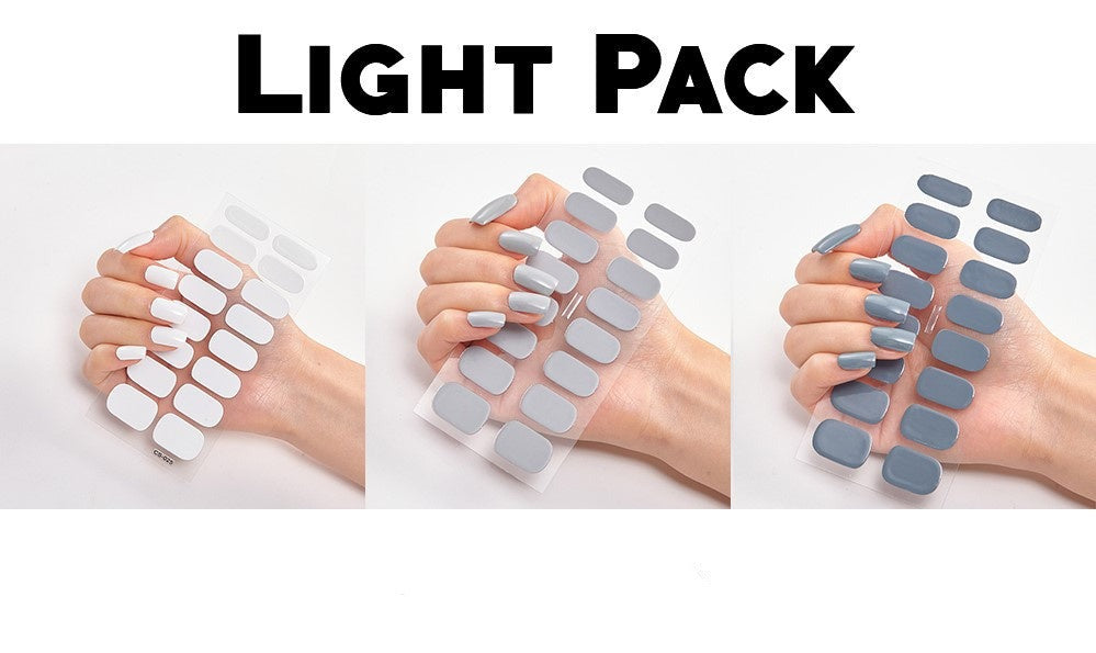 Triple bundle featuring three sets of nail wraps in white, light gray, and dark gray shades held in a hand.
