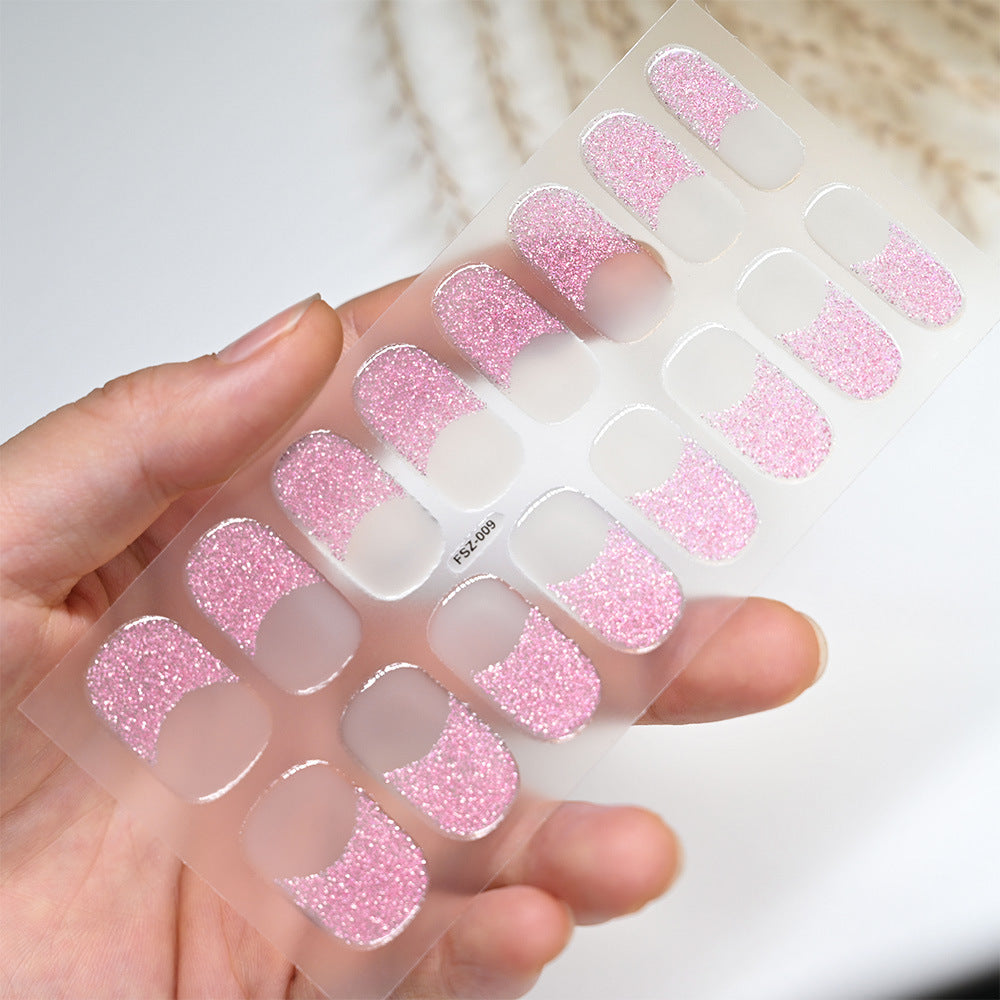 French glitter press-on nails in pink with a glitter finish, displayed on a clear backing held by a hand.
