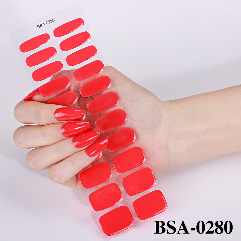Pastel Non-UV nail strips in a hand, featuring a glossy red finish and various sizes on a clear backing.