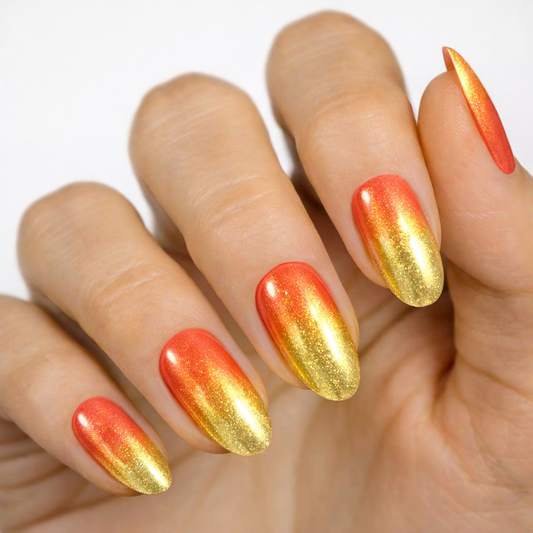 Currant™ nail wraps featuring a gradient design with orange and gold colors on long, almond-shaped nails.