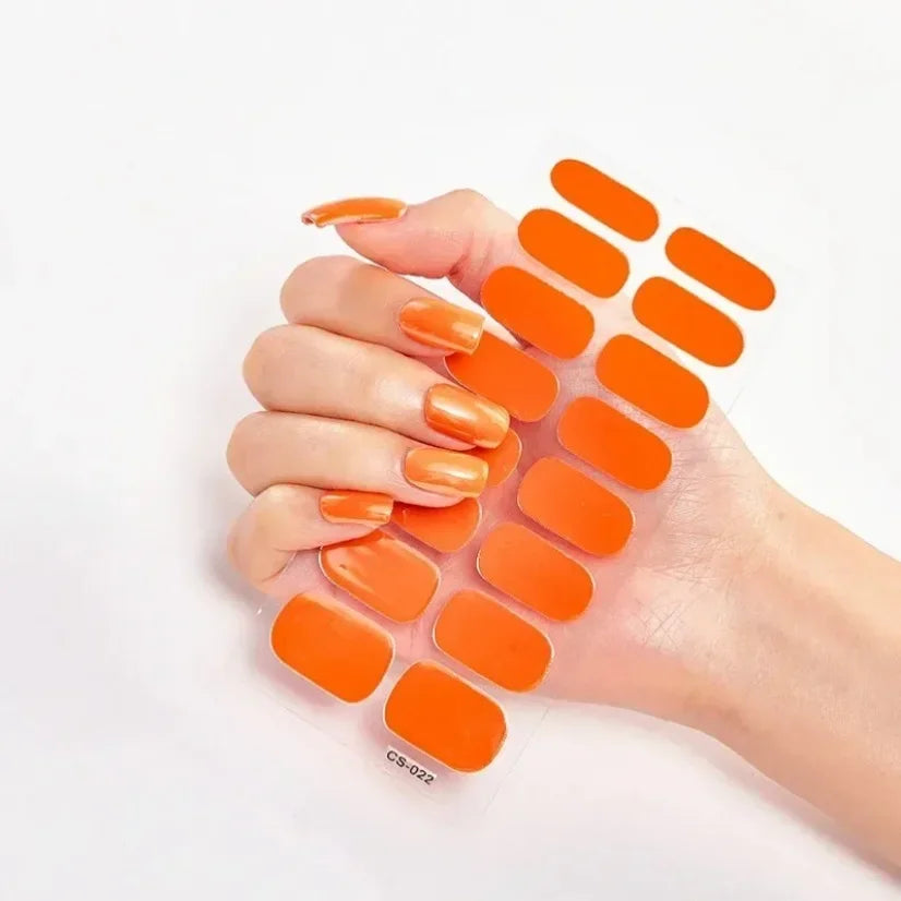 Currant™ nail wraps in various orange shades displayed on a hand, featuring a glossy finish and multiple sizes.