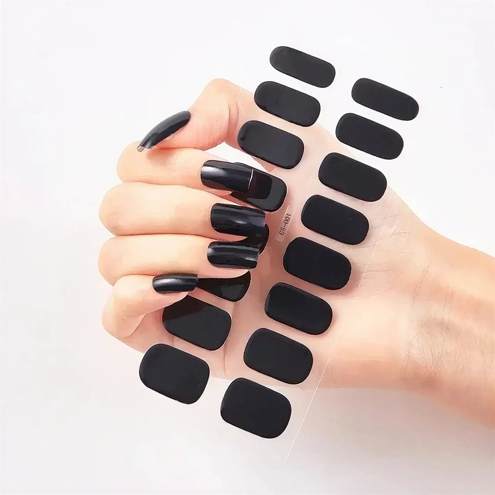 Currant™ Starter Kit with a hand displaying long black nails holding black nail strips in various sizes.