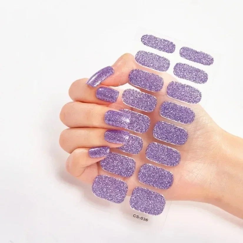 Currant™ Star purple glitter nail wraps displayed on a hand with long nails, showcasing various sizes and shapes.
