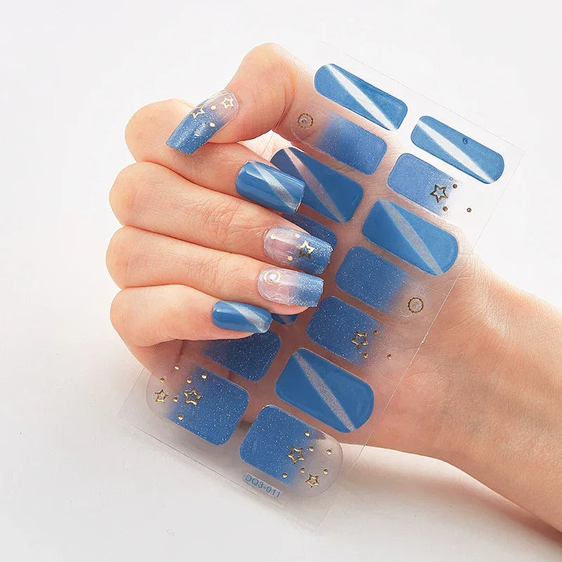 Currant™ Marble nail wraps featuring blue shades, glitter, and star designs on a hand holding the product sheet.