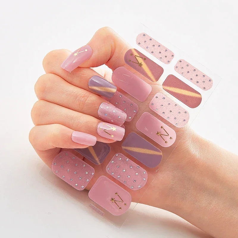 Currant™ Marble nail stickers in various pink shades with gold accents and glitter, displayed on a hand.