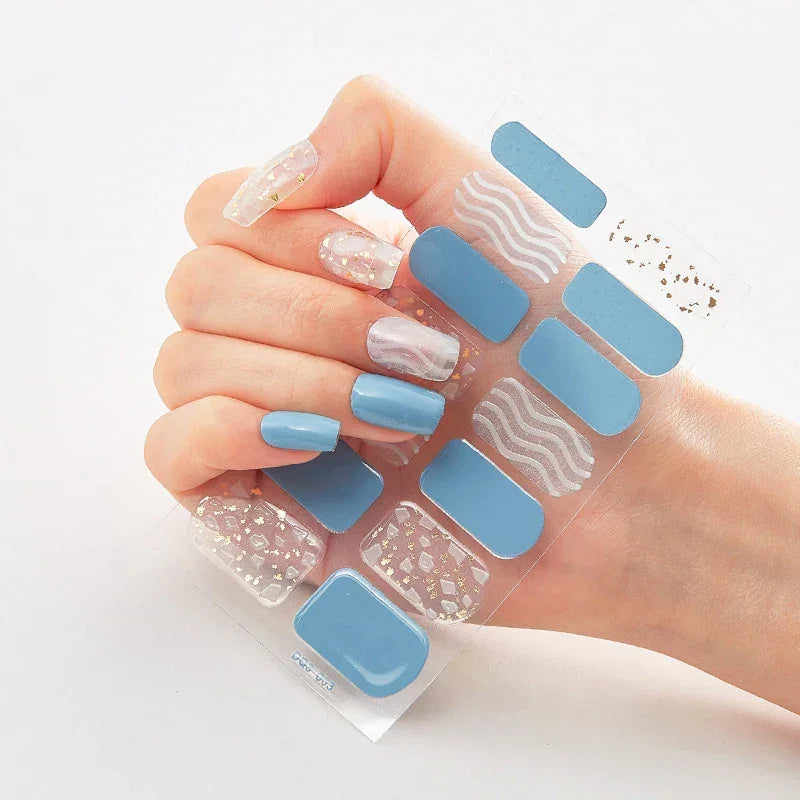 Currant™ Marble nail wraps featuring blue, marble, and glitter designs on a hand holding the product sheet.