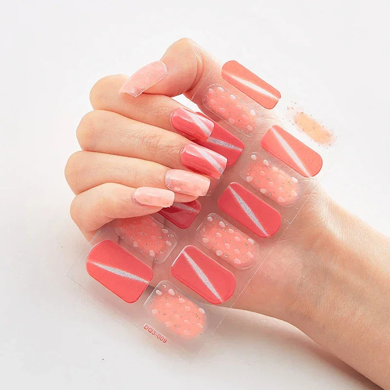 Currant™ Marble nail set featuring various shades of pink with designs, including dots and stripes, on a clear backing.