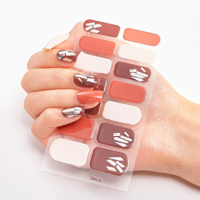 Currant™ nail wraps in red, white, and silver designs held by a hand with manicured nails.