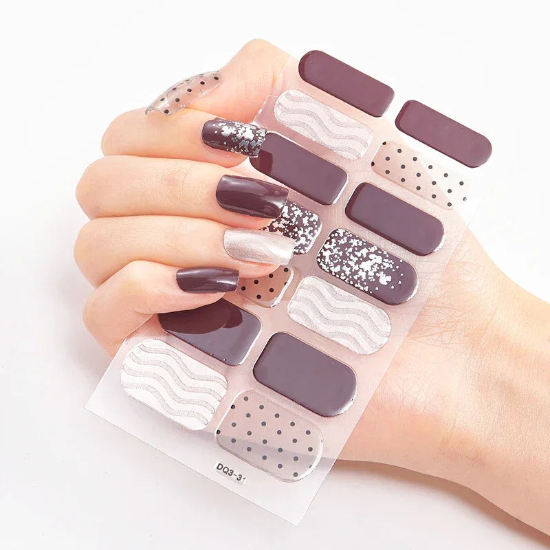 Currant™ nail wraps displayed on a hand, featuring purple, silver glitter, wavy patterns, and polka dots.