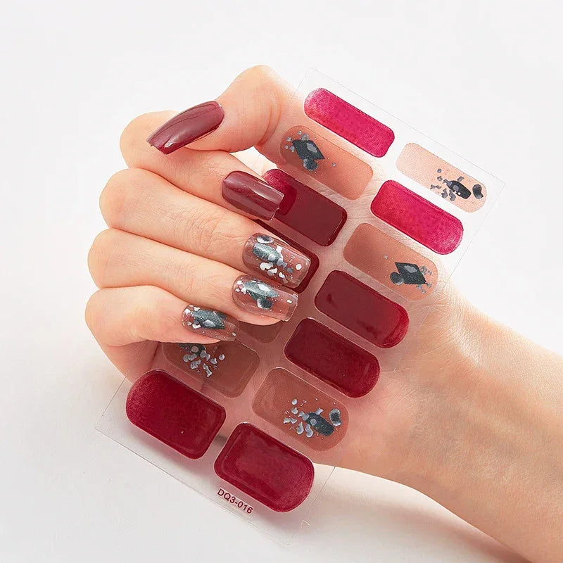 Currant™ Marble nail wraps displayed on a hand with dark red and nude shades, featuring floral designs.