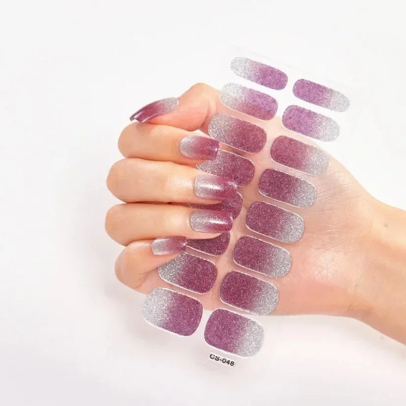 Currant™ Fade nail wraps featuring a gradient of purple to silver with a glossy finish, held in a hand.