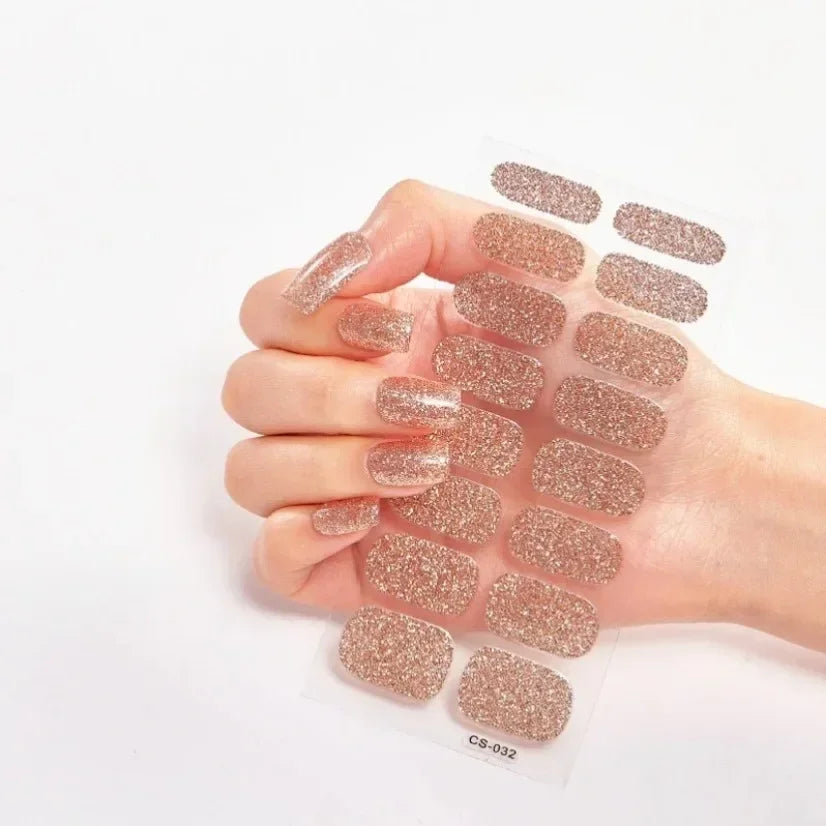 Currant™ Star nail wraps featuring a rose gold glitter design on a hand holding the product sheet.