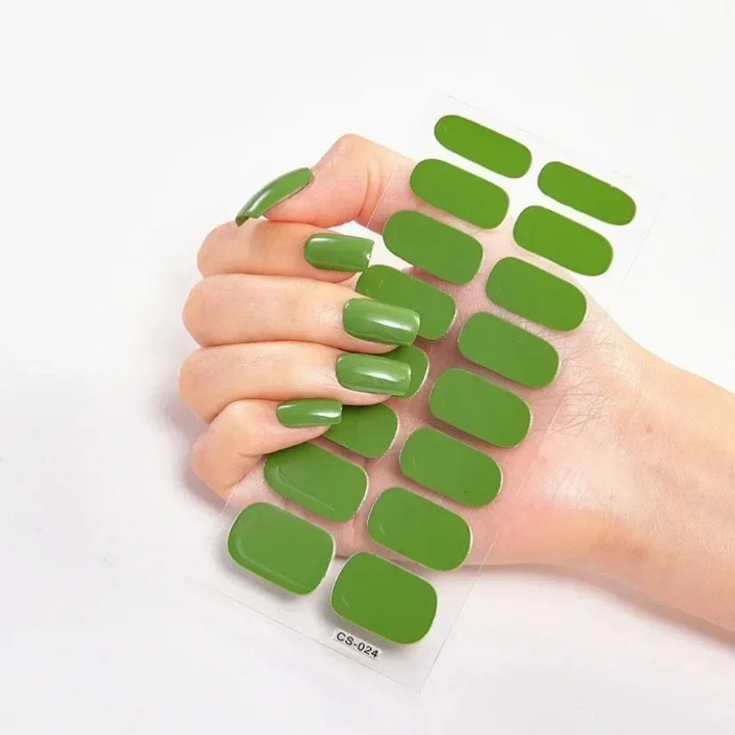 Currant™ nail wraps in a sheet alongside a hand with long, glossy green press-on nails.