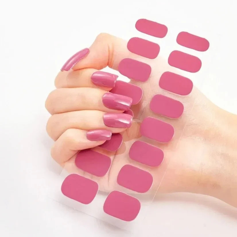 Currant™ nail wraps in various pink shades displayed on a hand, with multiple sizes on a clear backing.