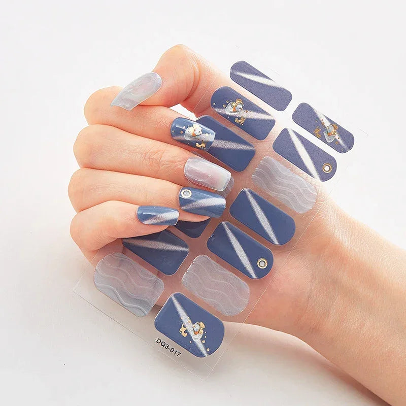 Currant™ Marble nail wraps with various blue shades and decorative designs on a hand holding the packaging.