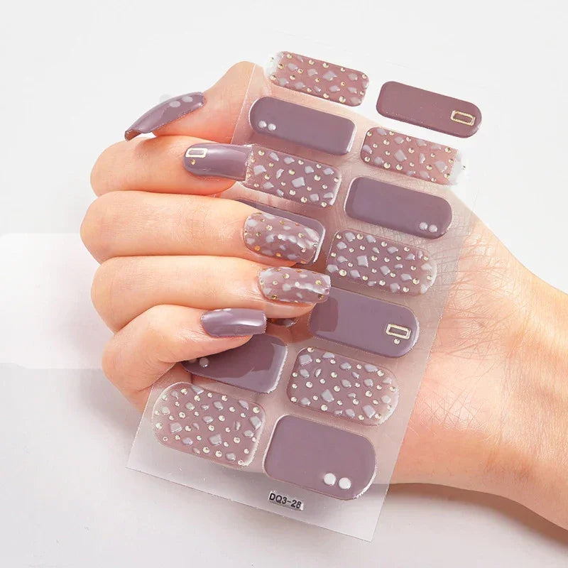 Currant™ Star press-on nails with solid lavender and speckled designs on a clear backing, displayed on a hand.