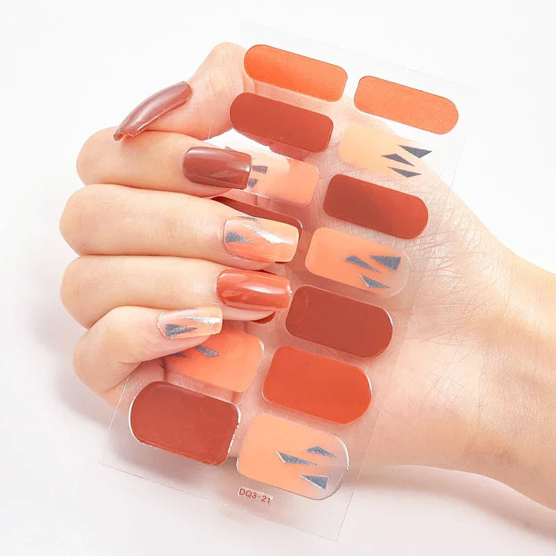 Currant™ Marble nail wraps featuring various shades of red and orange with metallic accents on a hand display.