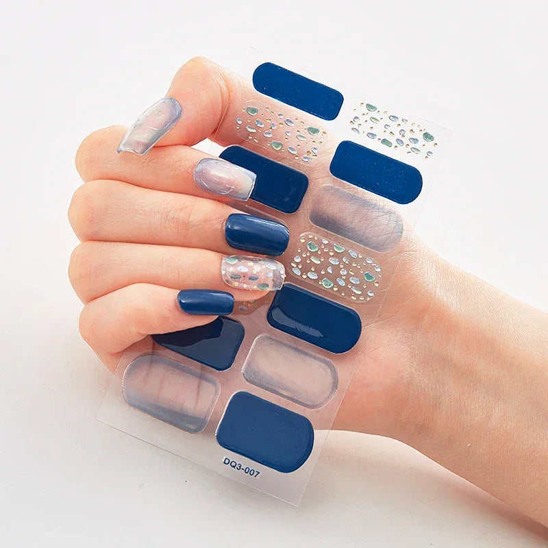 Currant™ Marble nail wraps featuring dark blue, clear, and silver designs with various patterns on a hand.