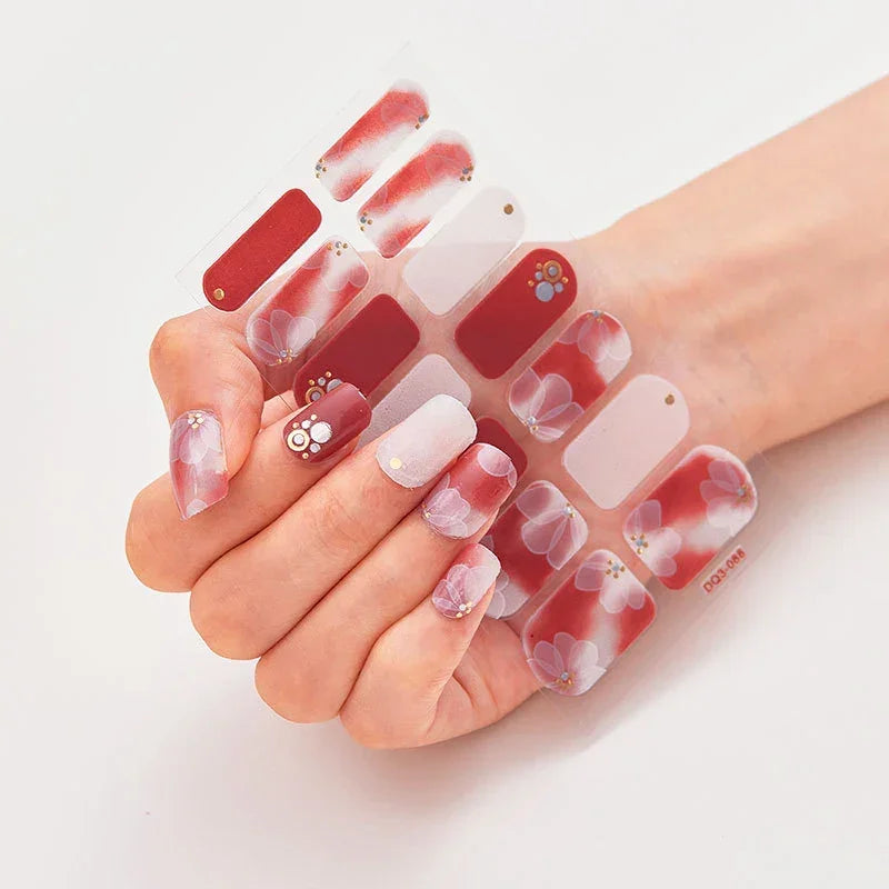 Currant™ Marble nail design featuring red and white floral patterns on a hand with manicured nails.