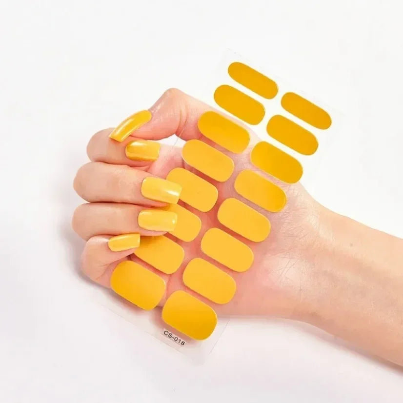Currant™ nail wraps in yellow, displayed in a hand with various sizes and shapes on a white background.