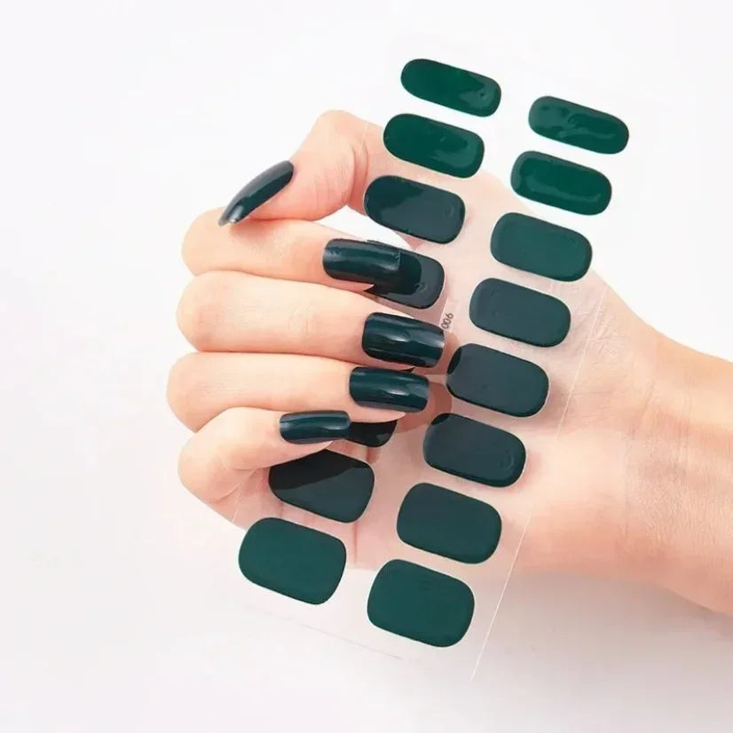 Dark green currant nail wraps displayed on a hand with long, glossy nails against a white background.