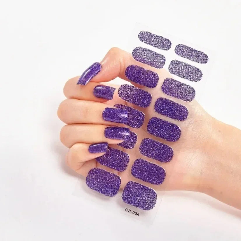 Currant™ Fade purple glitter nail wraps on a hand with long, manicured nails, showing various sizes and shapes.