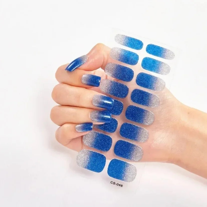 Currant™ Fade nail wraps featuring a gradient blue design with glitter, displayed on a hand.