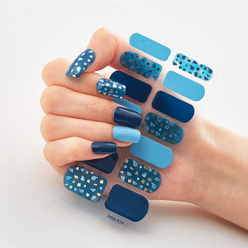 Currant™ Marble nail wraps featuring various shades of blue with geometric patterns and a hand displaying the designs.