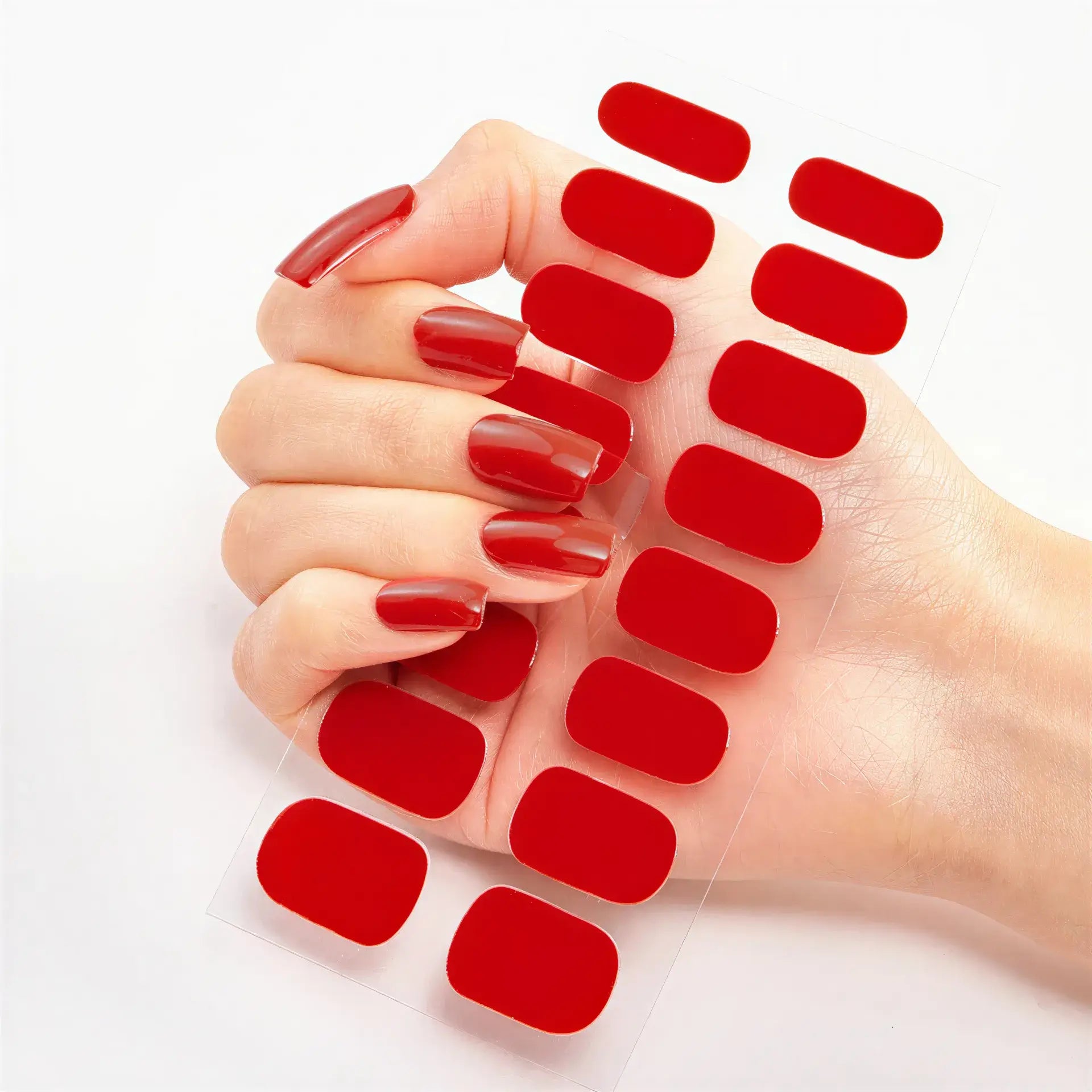 Currant™ nail wraps in red on transparent backing, with a hand showcasing long, manicured nails.