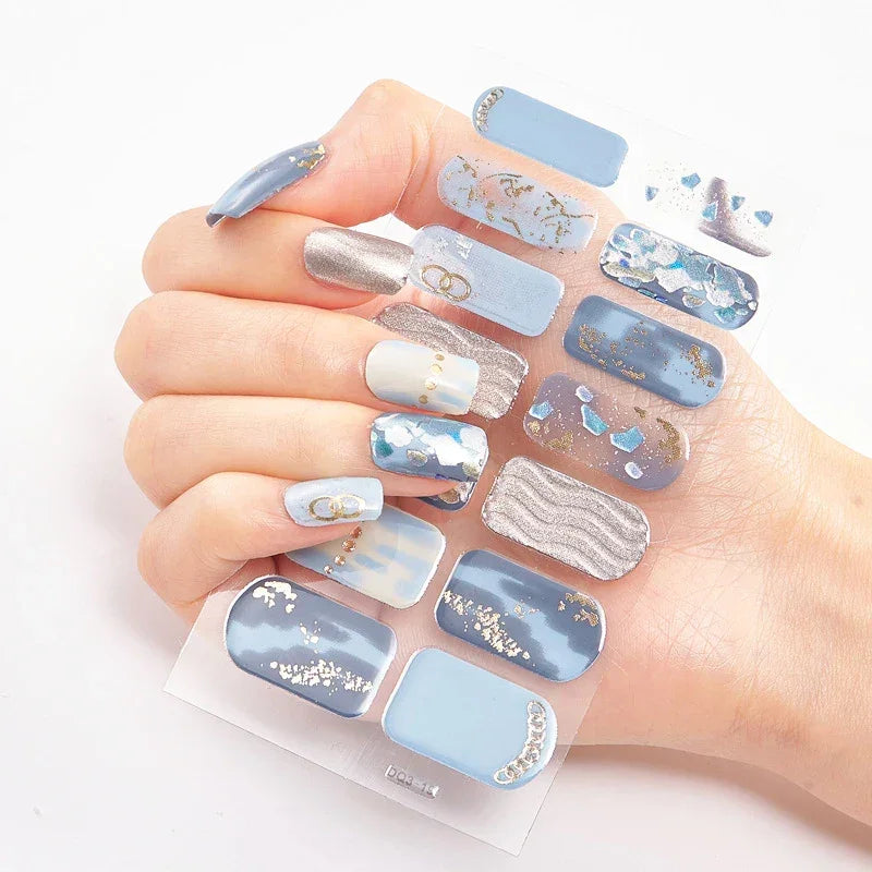 Currant™ Marble nail set featuring various blue shades, silver accents, and decorative designs on a clear backing.