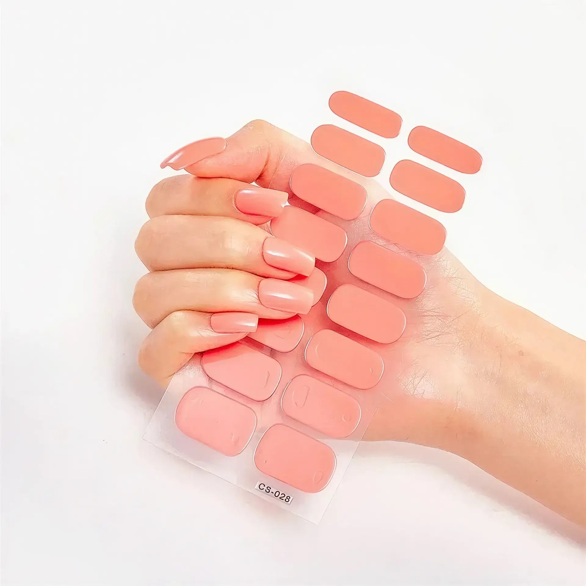 Currant starter kit with a hand holding peach-colored nail wraps in various sizes against a white background.