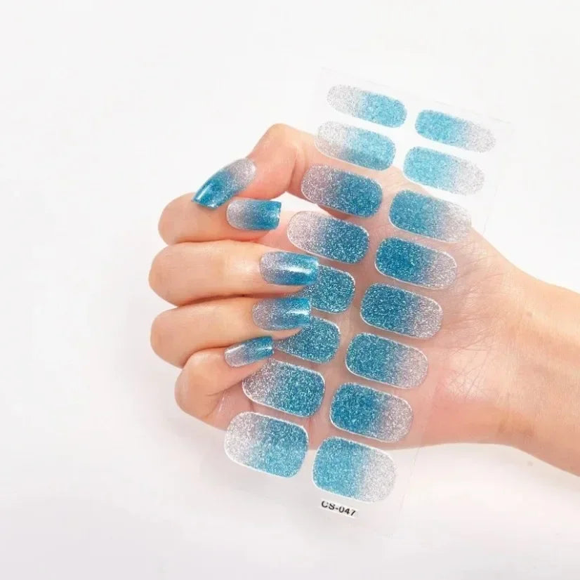 Currant™ Fade nail wraps featuring a gradient blue design with glitter accents on a clear backing.