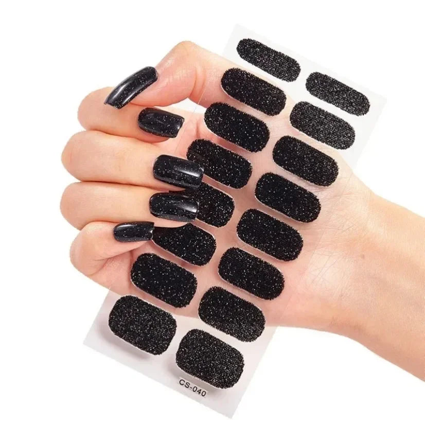 Currant™ Star black glitter nail wraps displayed on a hand, showcasing various sizes and shapes.