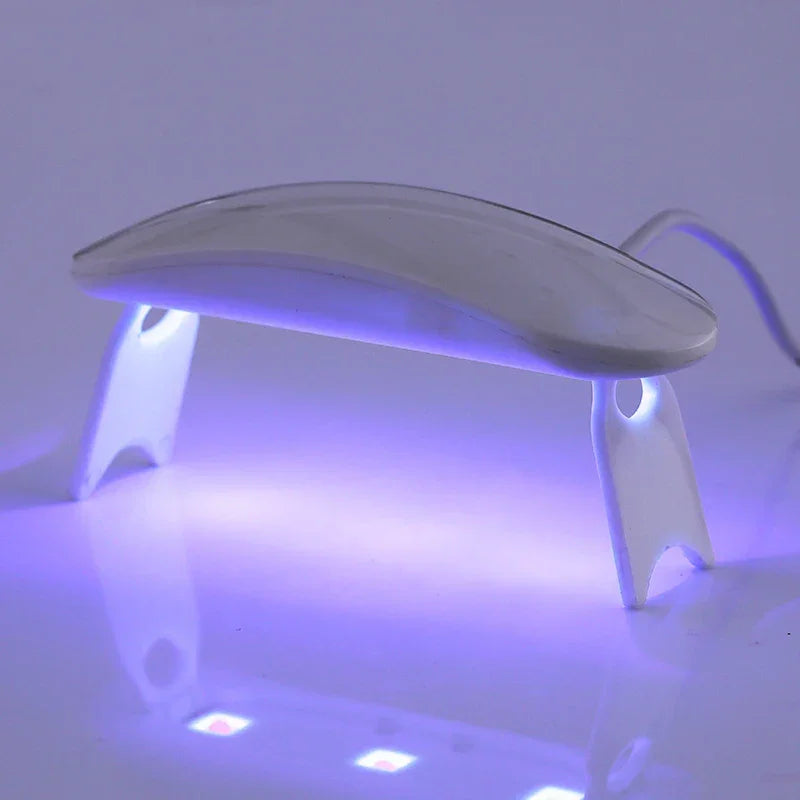 Currant UV lamp with a sleek white design and purple light, positioned on a reflective surface.