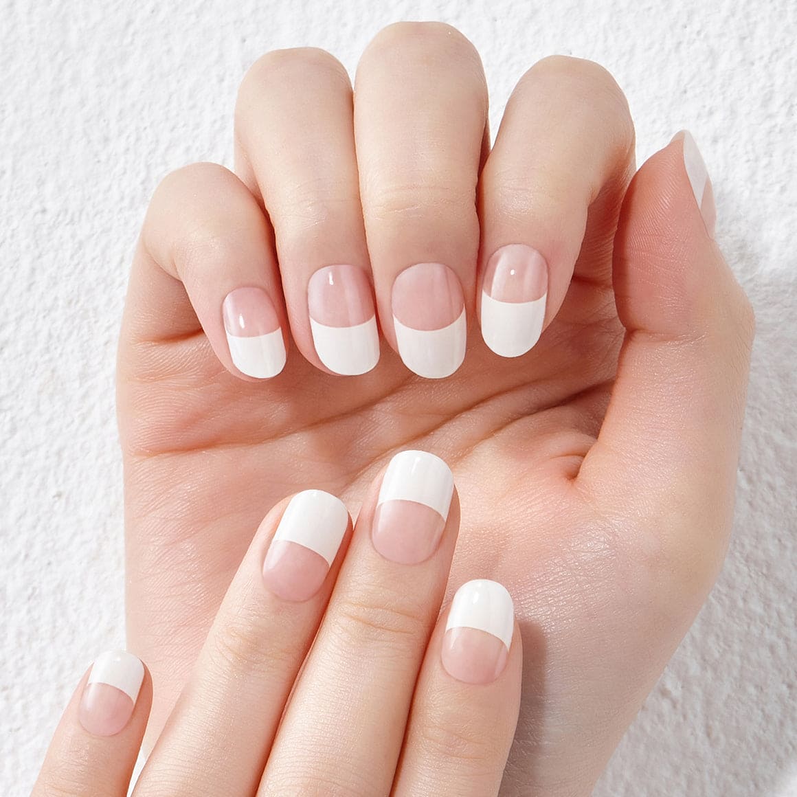 White French-glitter line manicure with glossy white tips and natural pink base on well-groomed hands.