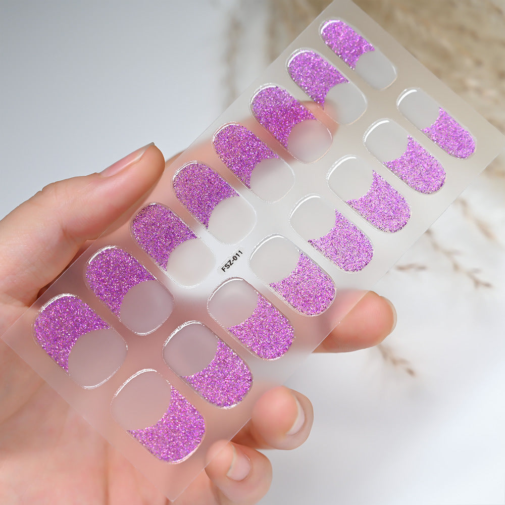 French Glitter press-on nails with a pink glitter design on a clear backing, held in a hand.
