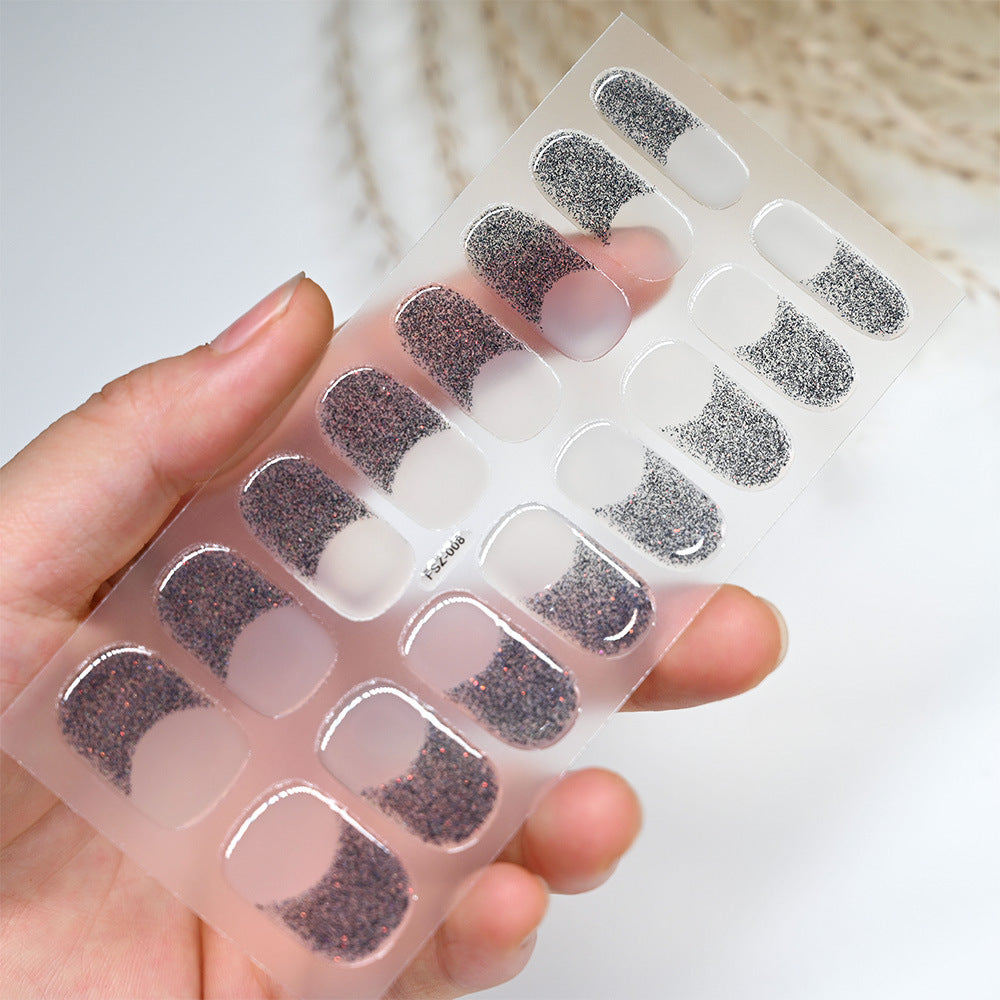 French Glitter nail strips featuring a mix of black and silver glitter on a clear backing, held in a hand.