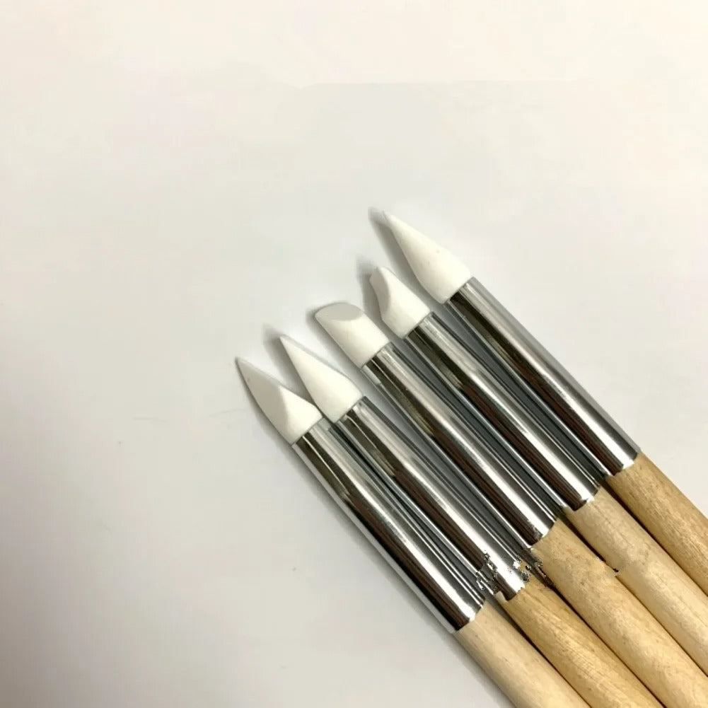 Set of four application wands with pointed white tips and wooden handles, arranged side by side on a light background.
